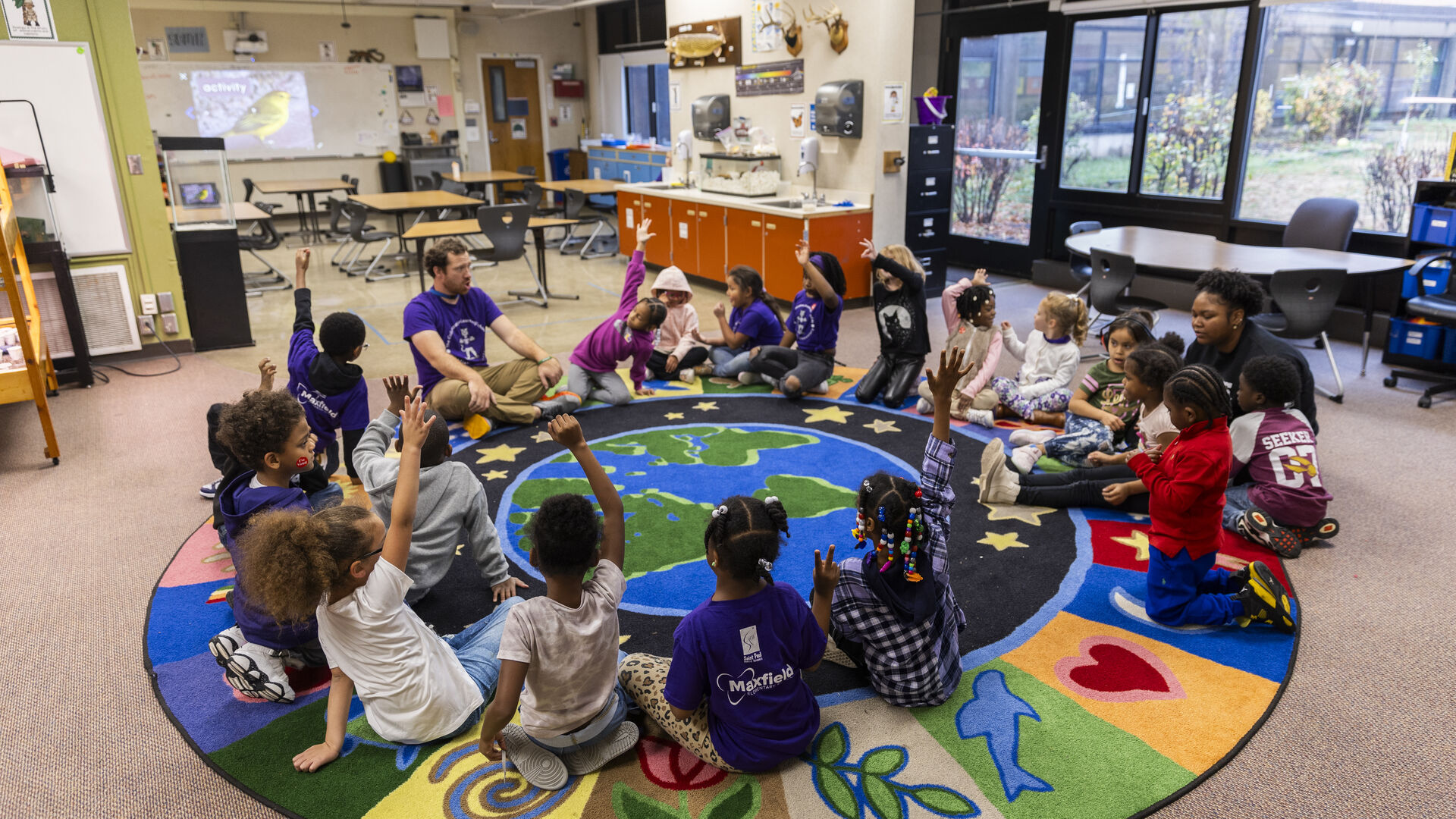 Teacher sitting with student at table helping student