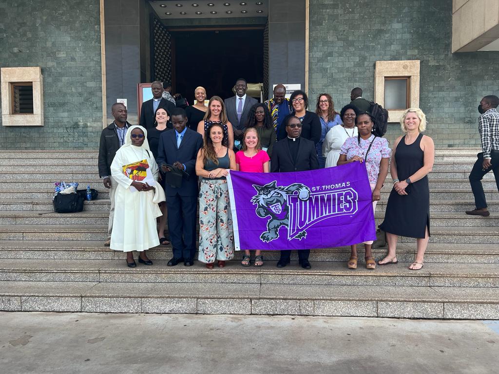 Group photo of St. Thomas students in Uganda with Tommie banner